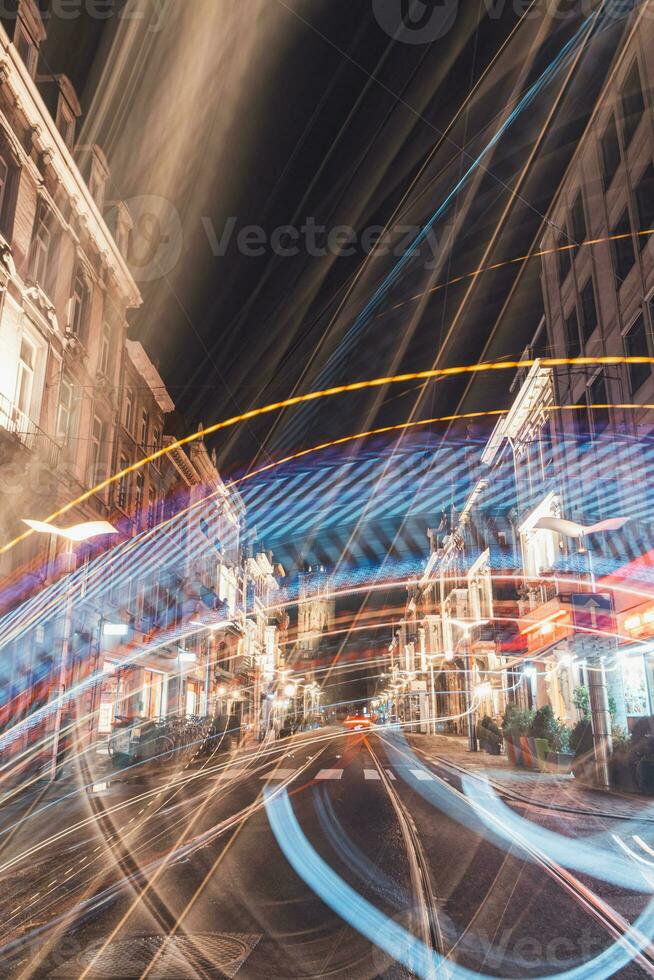 Blurred photo of Ghent's historic centre and a moving tram, during a dark night. Flanders region, Belgium