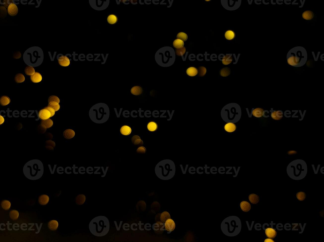 abstract bokeh yellow light orange and white glowing flare pattern black background photo