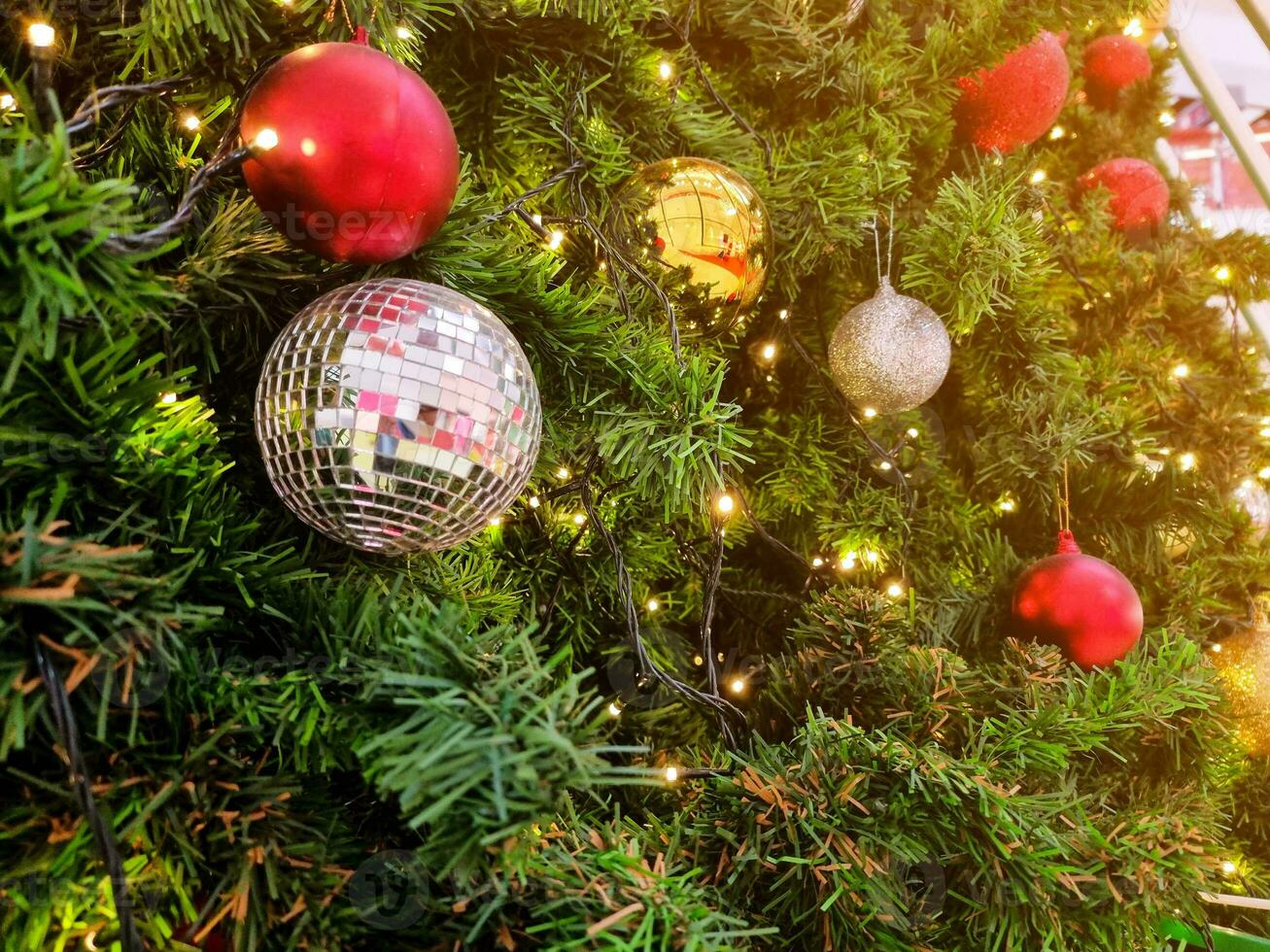 Happy new year cozy home interior with christmas tree and garlands small red and silver balls. blurred lights golden bokeh.Merry Christmas background. photo