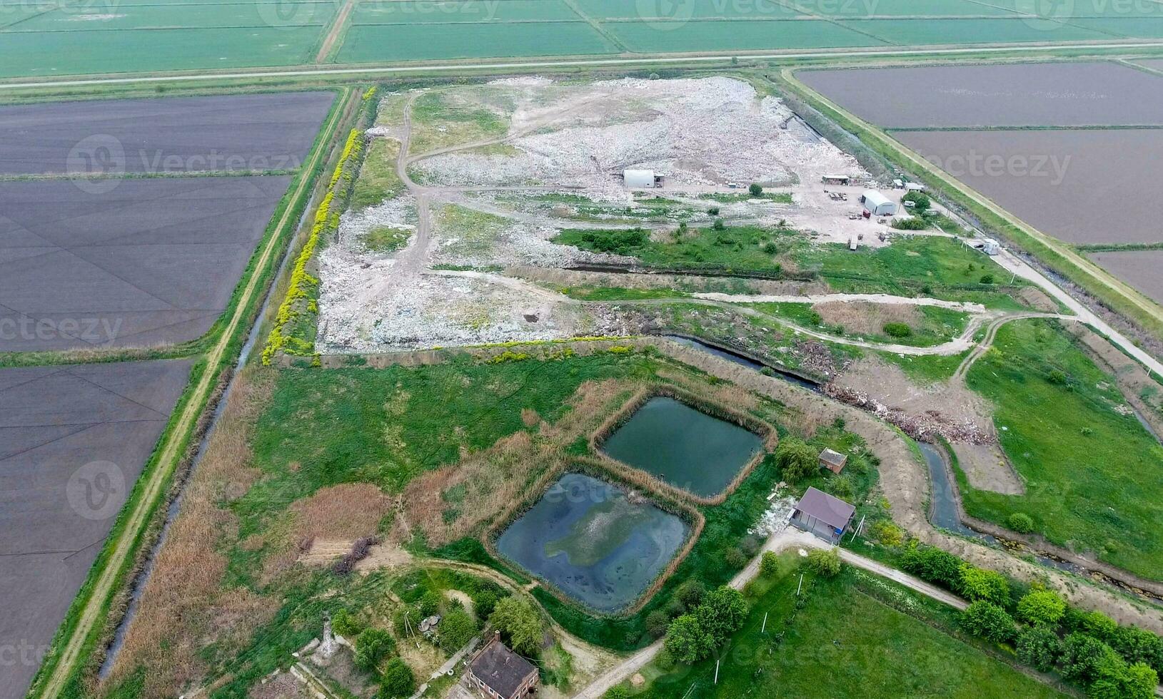 garbage dump with heaps of garbage and treatment facilities. Landfill of garbage outside the village photo