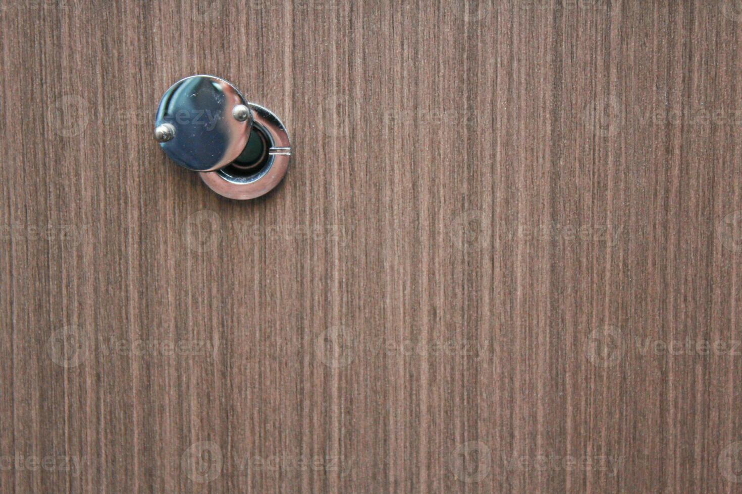 door peephole on the wood pattern door of a hotel room photo