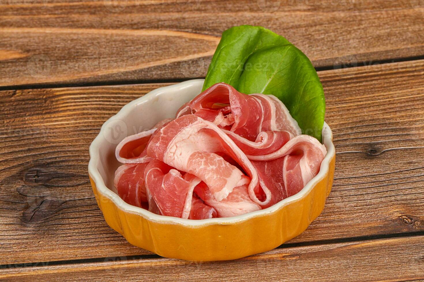 Sliced pork bacon in the bowl photo