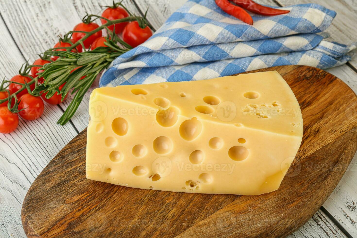 Maasdam cheese piece over board photo