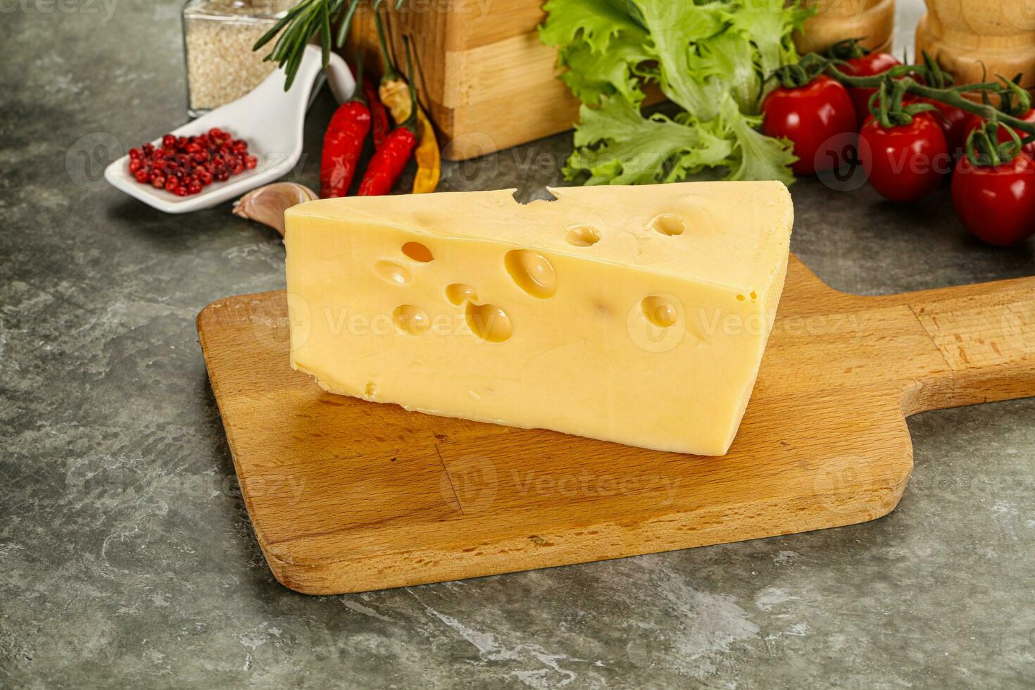 Swiss Maasdam cheese triangle over board photo