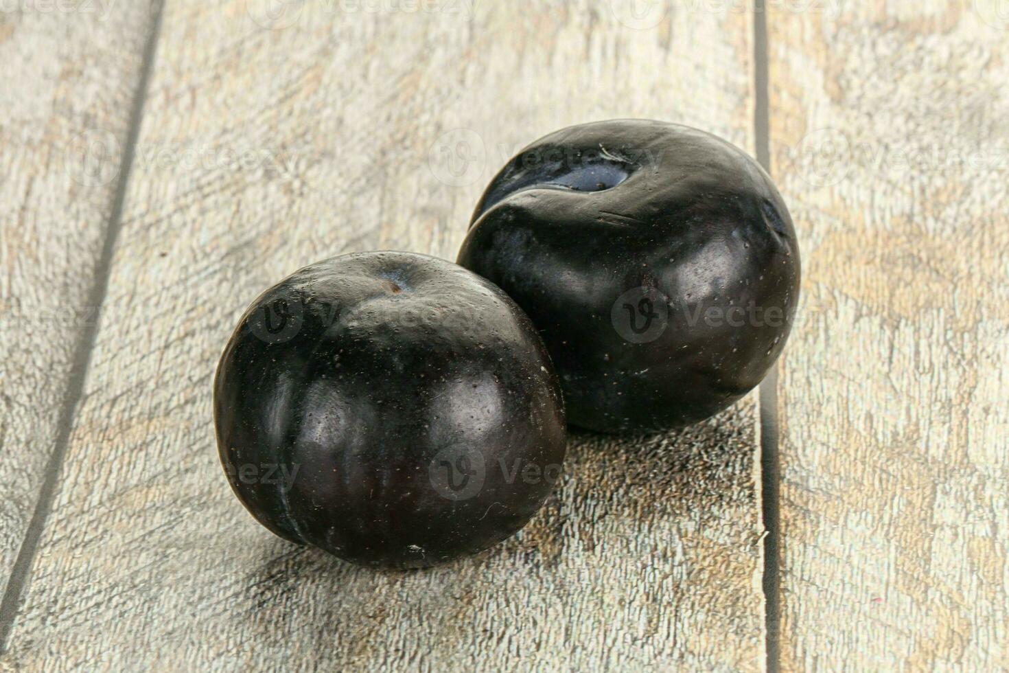 Two ripe sweet black plums photo