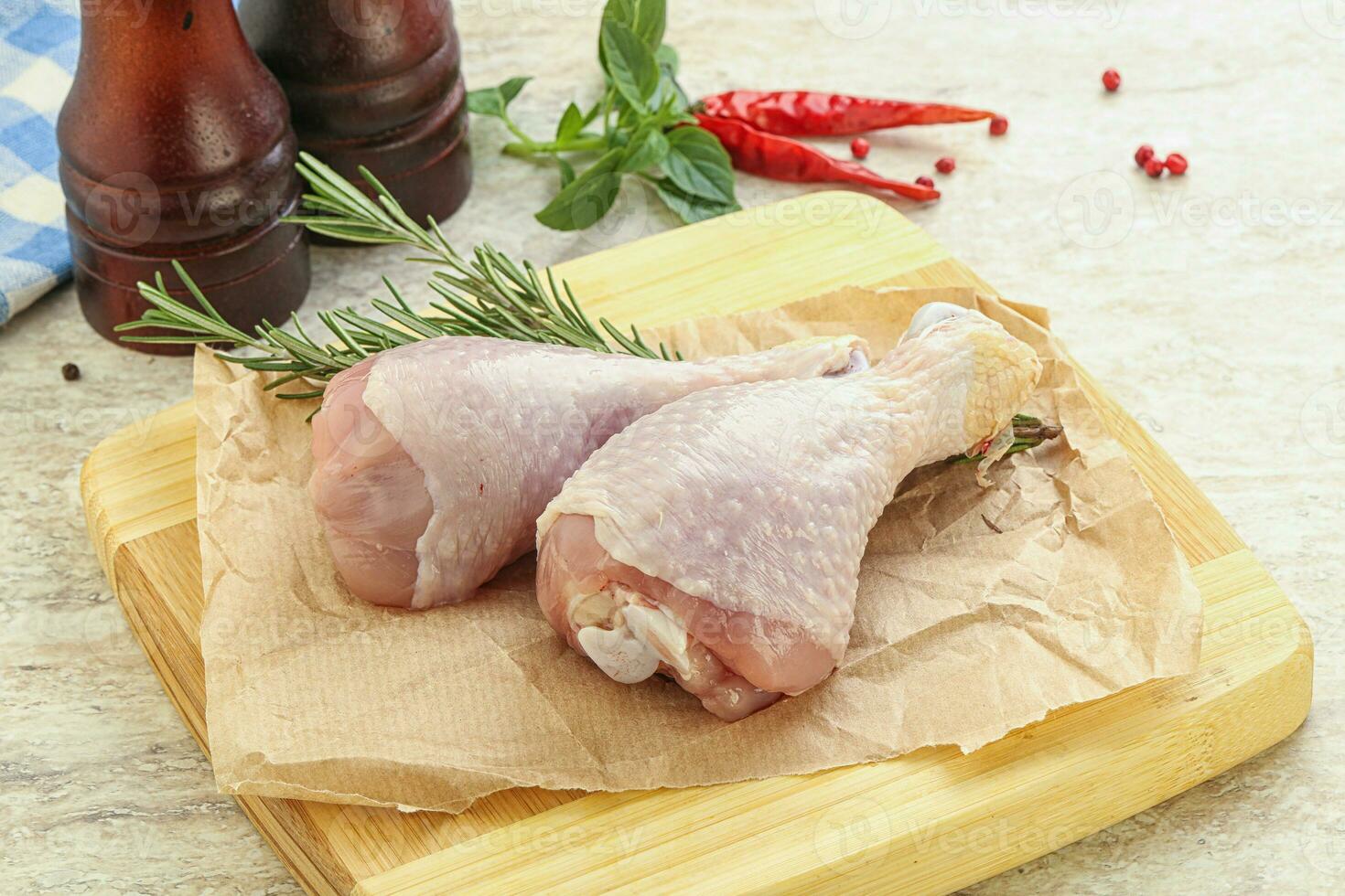 Raw chicken leg over board photo