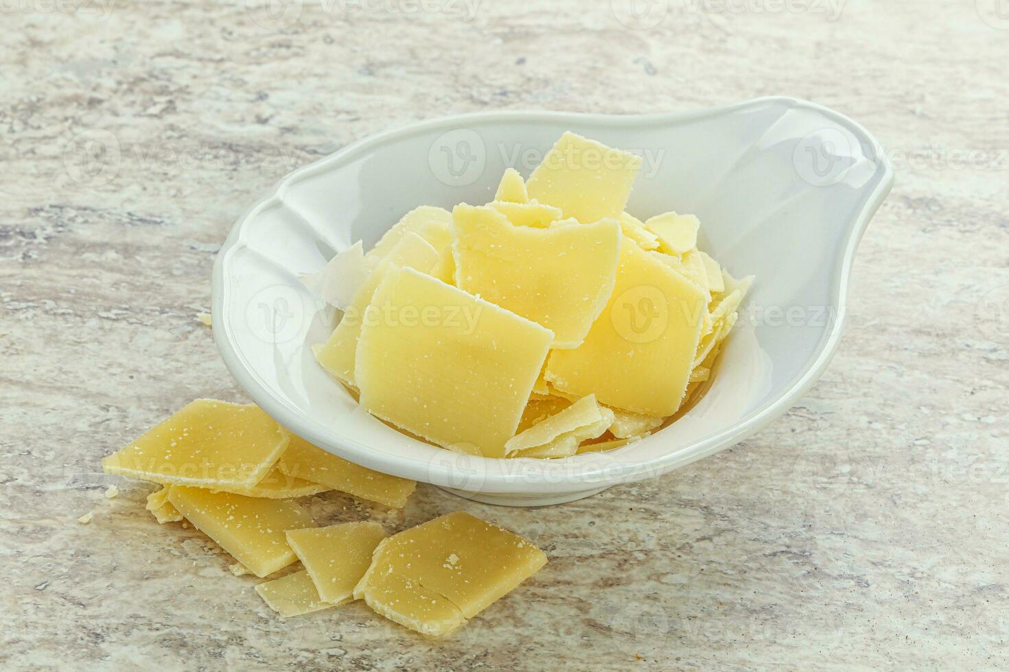 Sliced parmesan cheese heap in the bowl photo