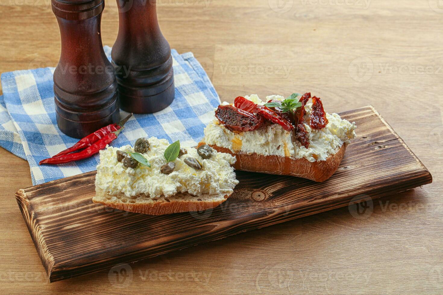 bruschetta with soft cheese capers and tomato photo