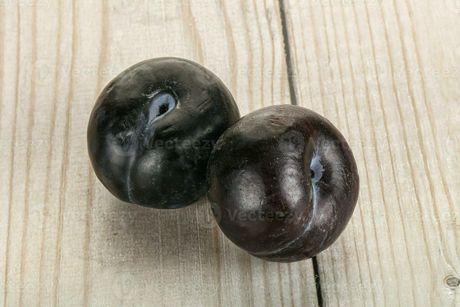 Two ripe sweet black plums photo