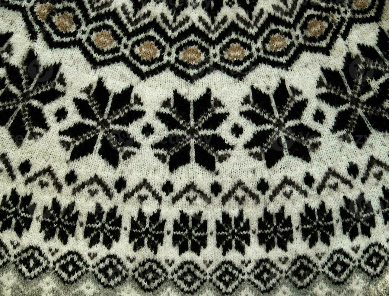 Black and white Winter Knitted Sweater Pattern Design with snowflakes. Handmade knitting wool fabric texture. Background of kniting patterns and ornament. photo