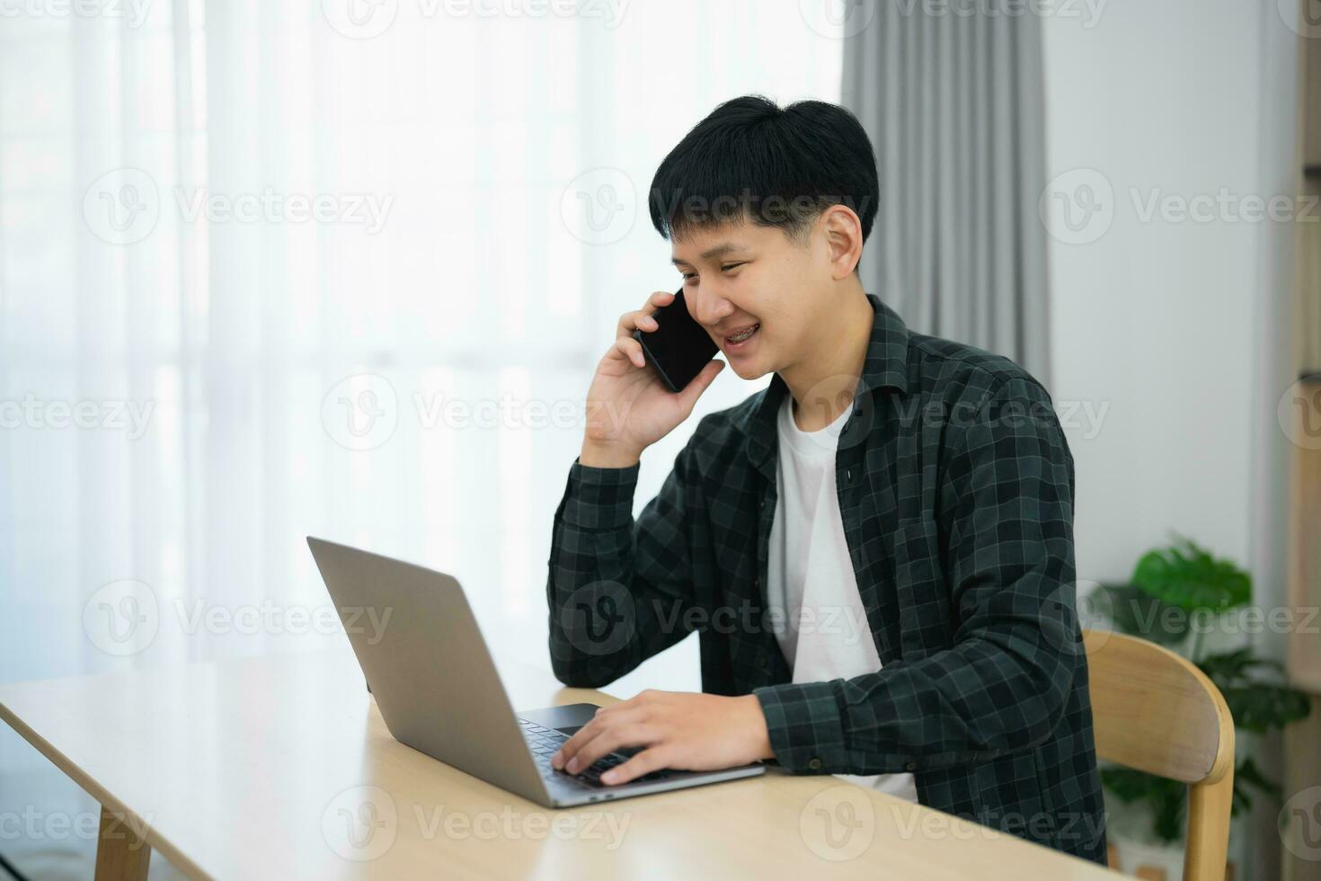 Freelance business man calling on mobile smartphone while working with laptop on table, businessman mobile phone to calling with customers or shopping online. Smart phone conversation conferrence. photo