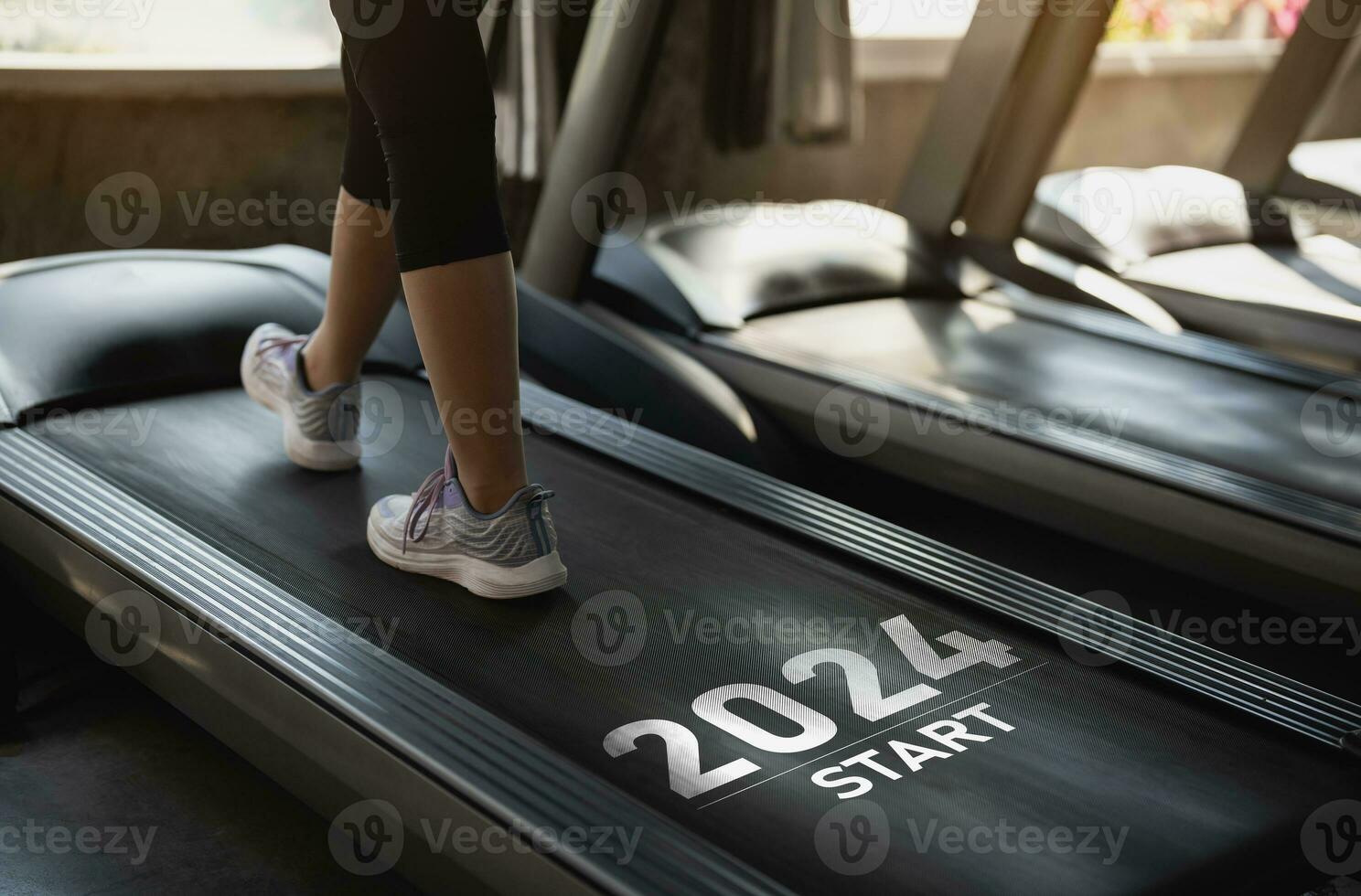 Happy new year 2024,2024 symbolizes the start of the new year. Close up of feet, sportswoman runner running on treadmill in fitness club. Cardio workout. Healthy lifestyle, guy training in gym. photo