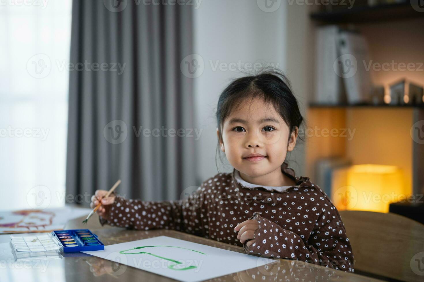 Cute little asian baby smiling painting with colorful paints using watercolor. Asian girl using paintbrush drawing color. Baby activity lifestyle concept. photo