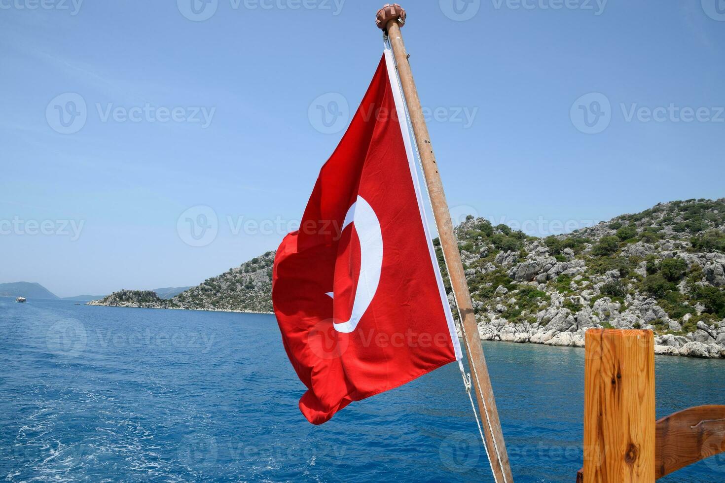 Turkey flag at the stern of a pleasure yacht. View of Mediterranean coast photo