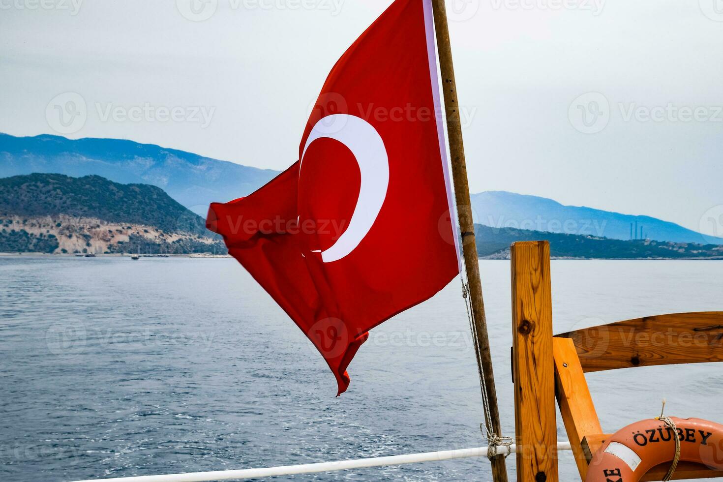 el bandera de Turquía revolotea en el viento en el cubierta de Placer yate. foto