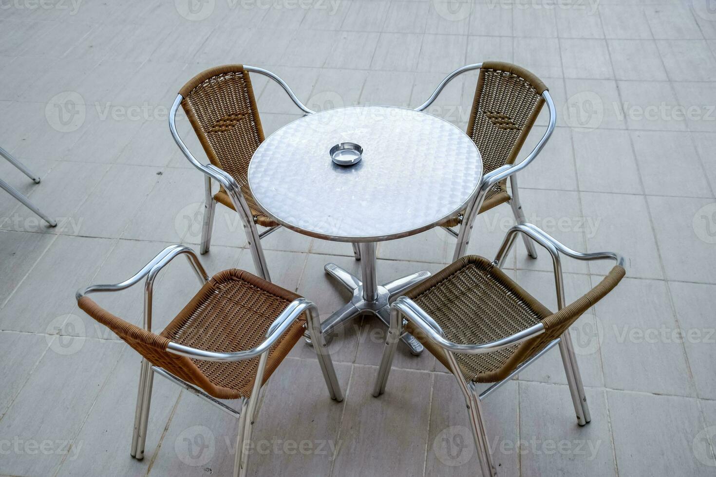 Metal tables and chairs with wicker seats in outdoor cafe. photo