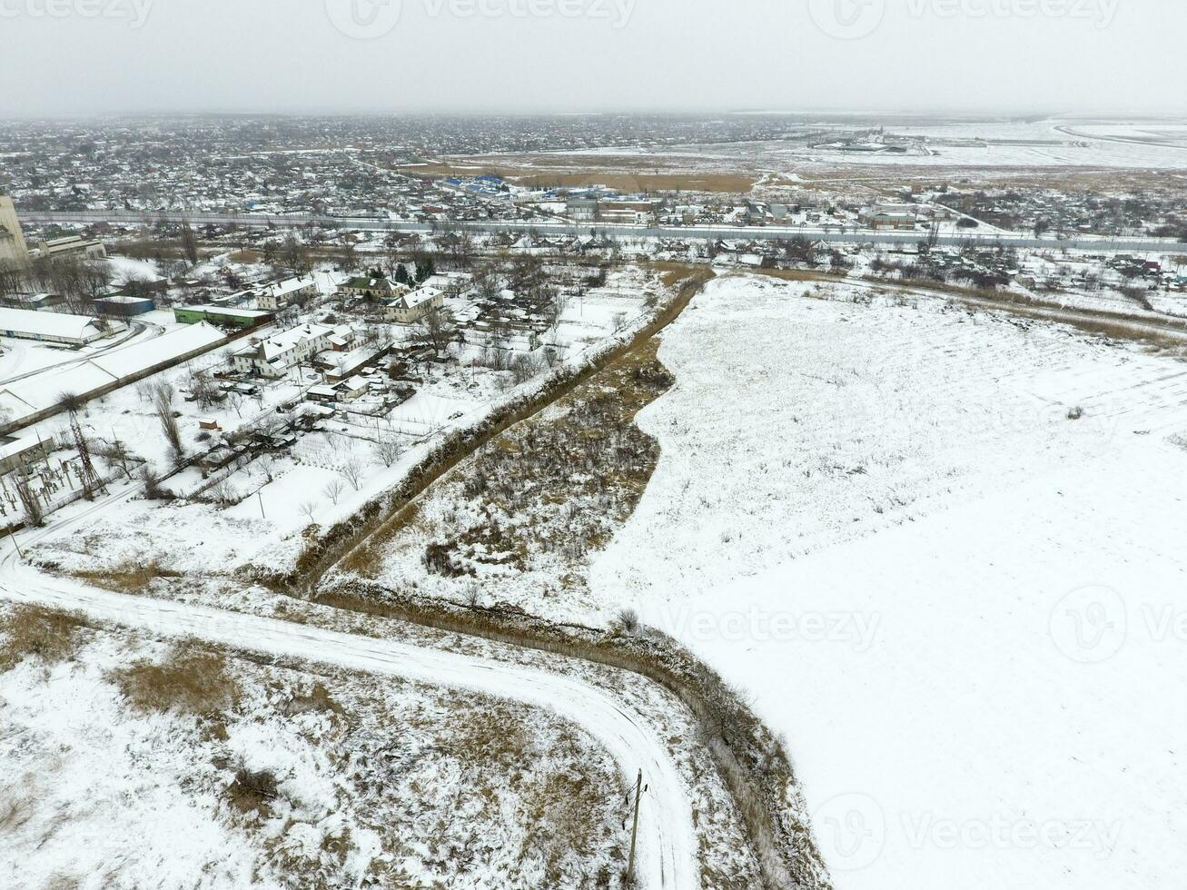 Sprinkled with snow grain elevator. Winter view of the old Soviet elevator. Winter view from the bird's eye view of the village. The streets are covered with snow photo