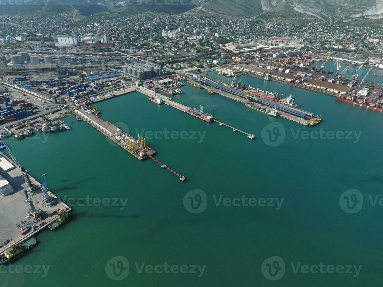 Industrial seaport, top view. Port cranes and cargo ships and barges. Loading and shipment of cargo at the port. View of the sea cargo port with a bird's eye view photo