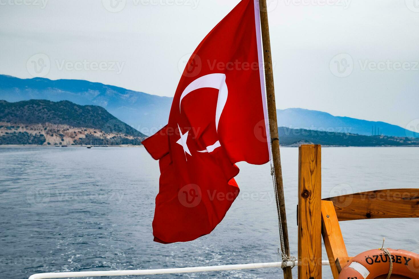 The flag of Turkey flutters in the wind on the deck of pleasure yacht. photo