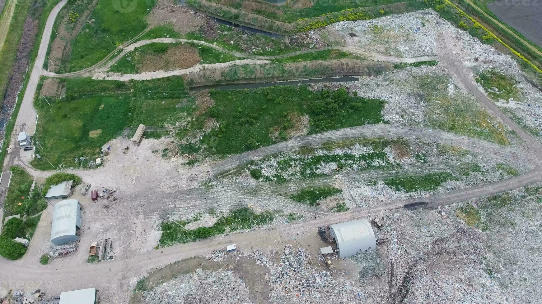 garbage dump with heaps of garbage and treatment facilities. Landfill of garbage outside the village photo