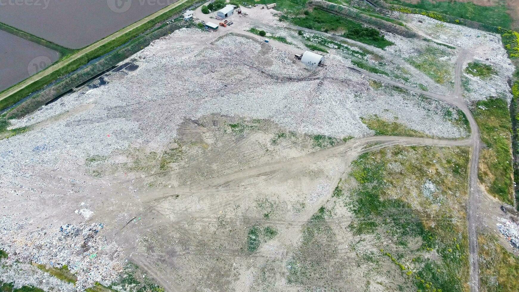 garbage dump with heaps of garbage and treatment facilities. Landfill of garbage outside the village photo