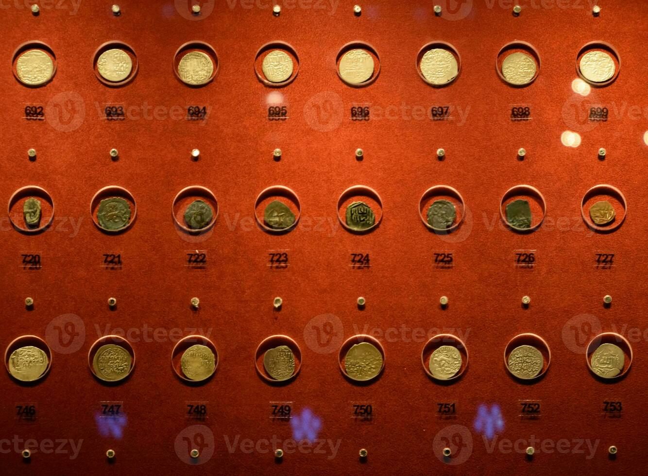 Coins at the Antalya Antiquities Museum. Old coins on the rack with light. photo