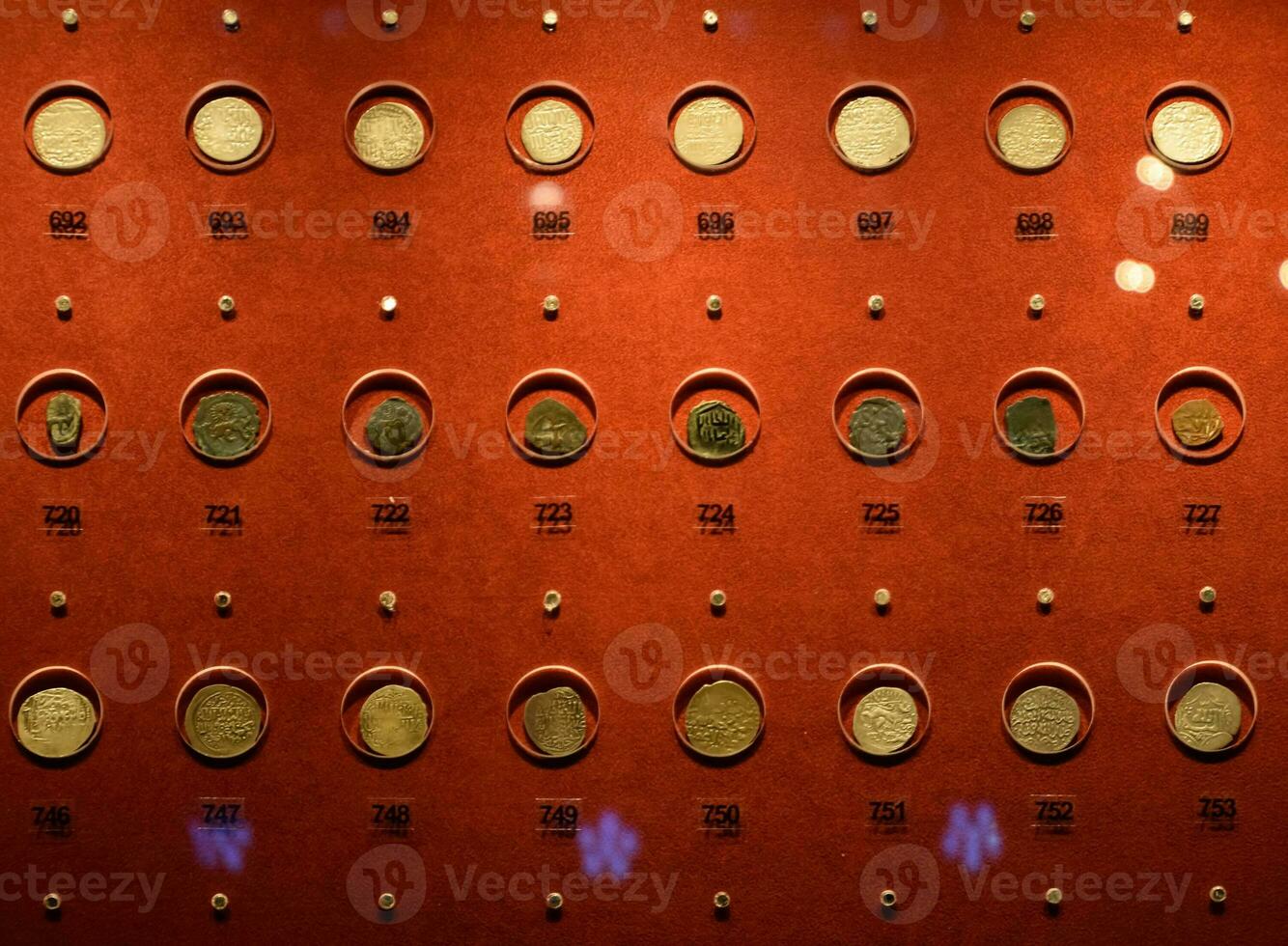 Coins at the Antalya Antiquities Museum. Old coins on the rack with light. photo