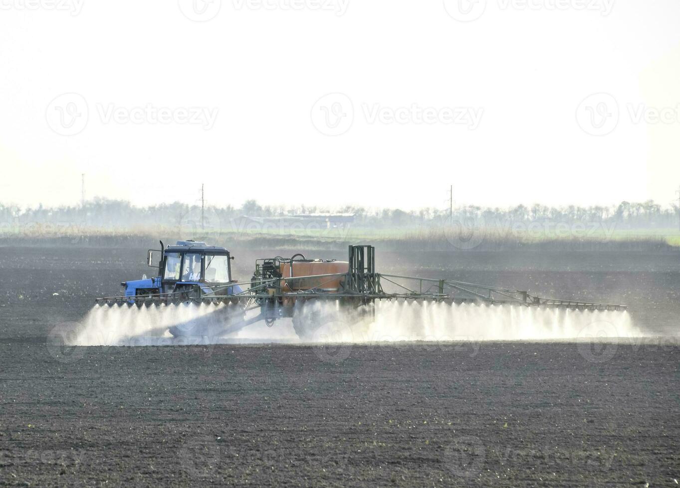 el tractor rociado herbicidas en el campo. química en agricu foto