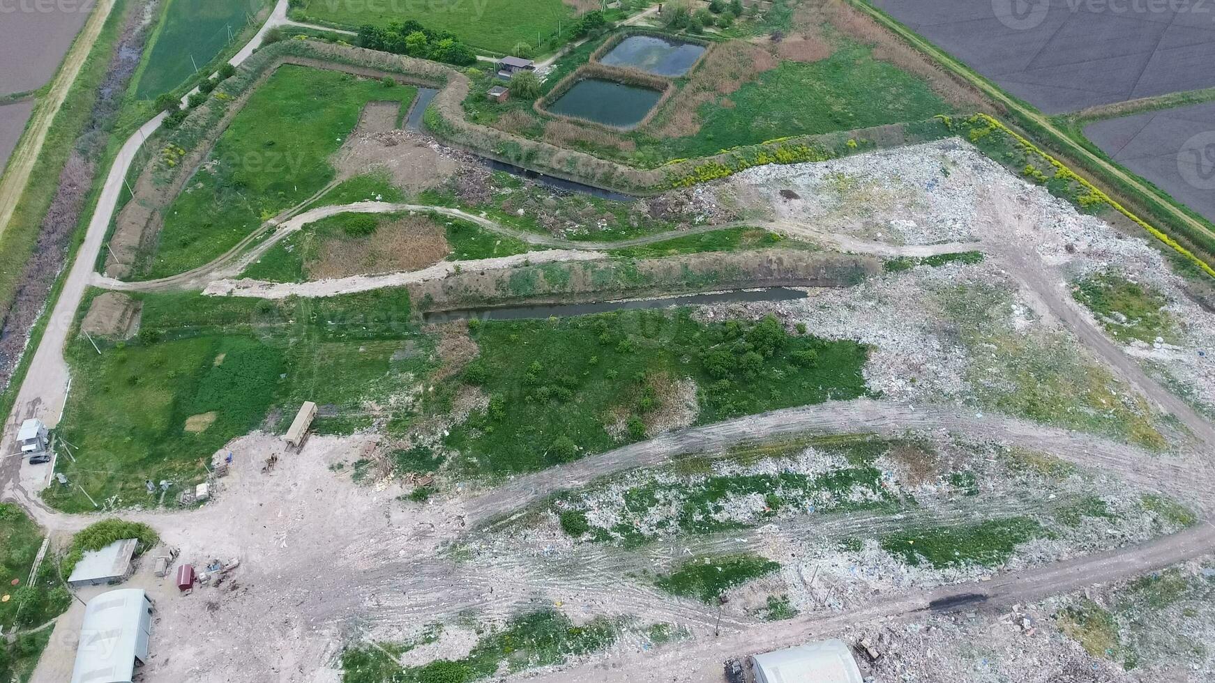 garbage dump with heaps of garbage and treatment facilities. Landfill of garbage outside the village photo