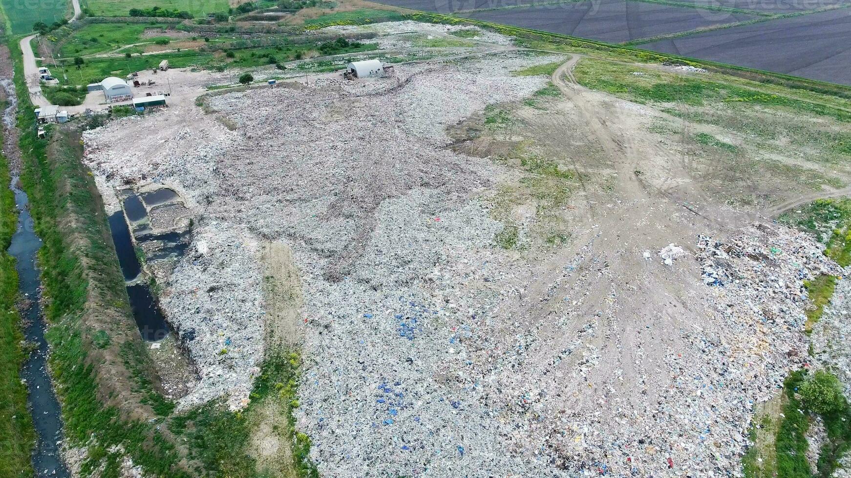 garbage dump with heaps of garbage and treatment facilities. Landfill of garbage outside the village photo