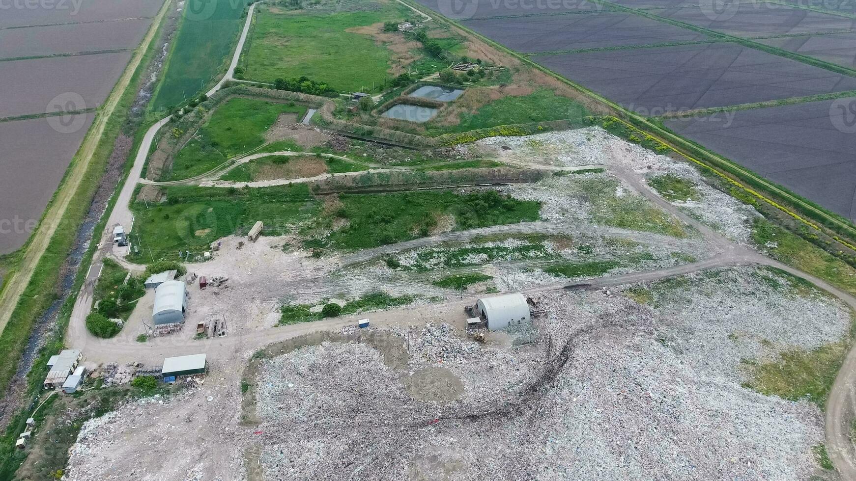 garbage dump with heaps of garbage and treatment facilities. Landfill of garbage outside the village photo
