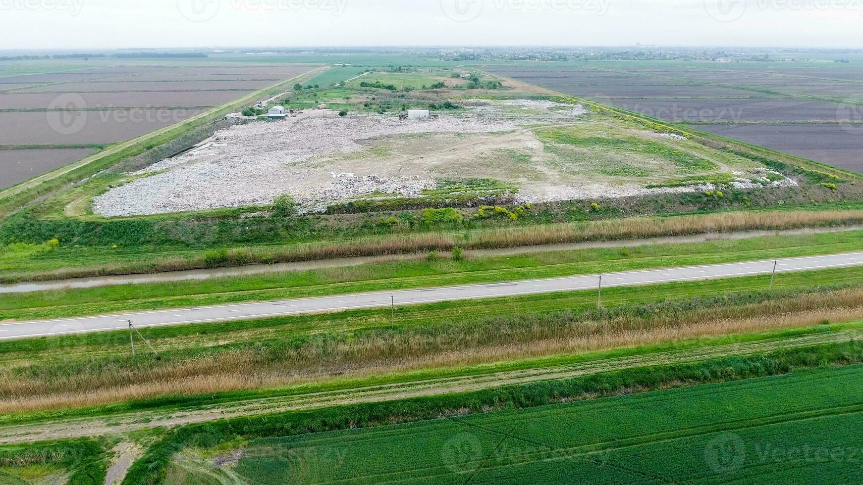 garbage dump with heaps of garbage and treatment facilities. Landfill of garbage outside the village photo