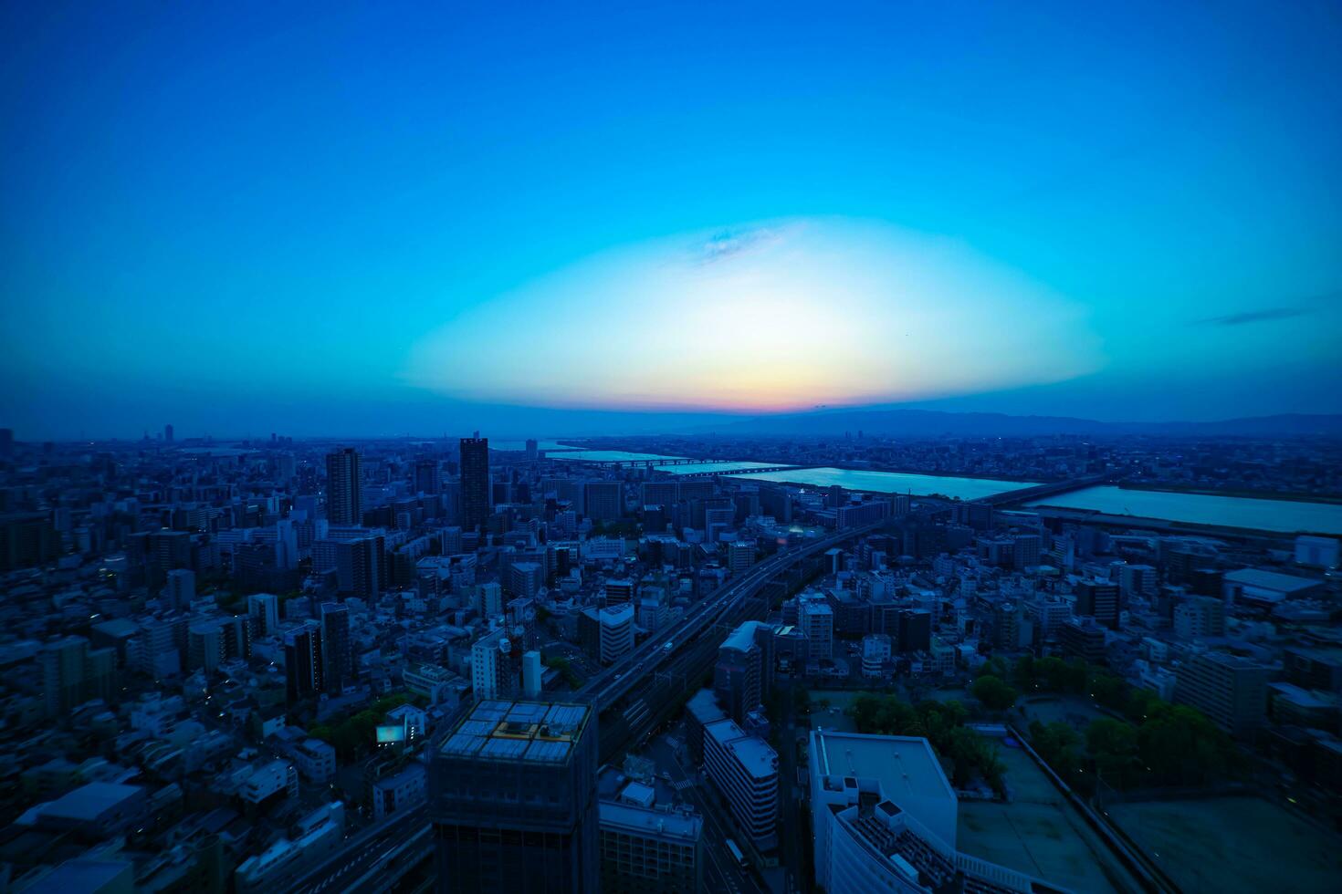 A dusk panoramic cityscape near Yodo river in Osaka wide shot photo