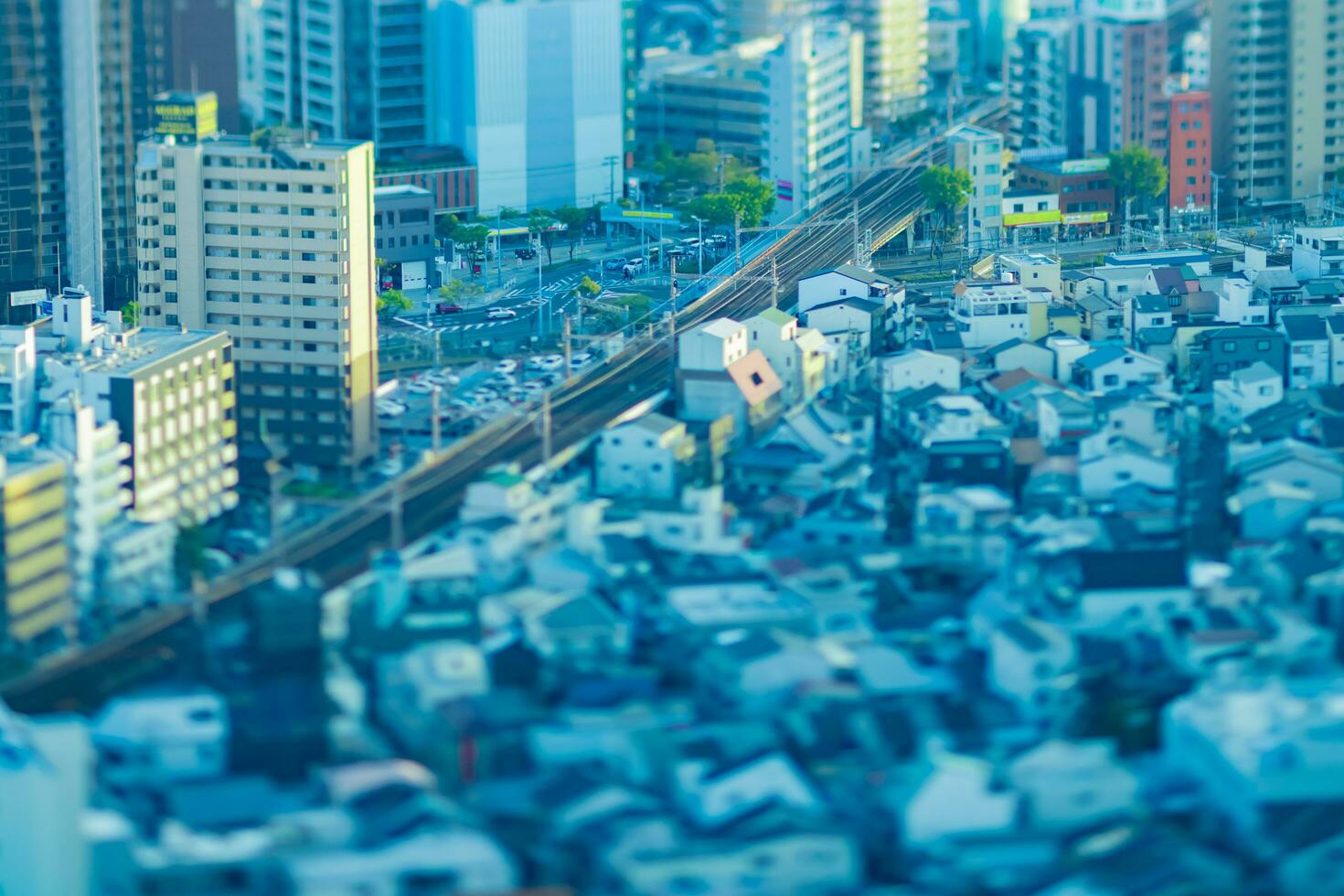 un oscuridad miniatura paisaje urbano por alto ángulo ver cerca el ferrocarril en Osaka foto