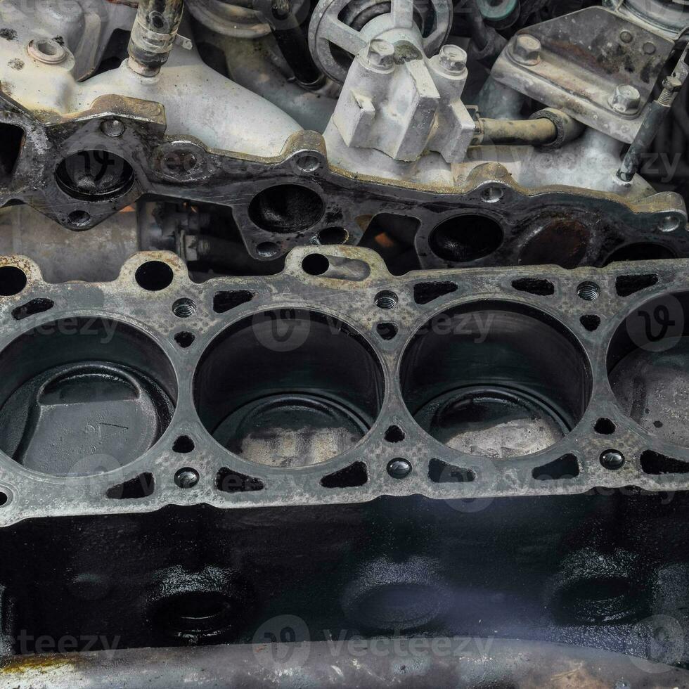 The cylinder block of the four-cylinder engine. Disassembled motor vehicle for repair. Parts in engine oil. Car engine repair in the service photo