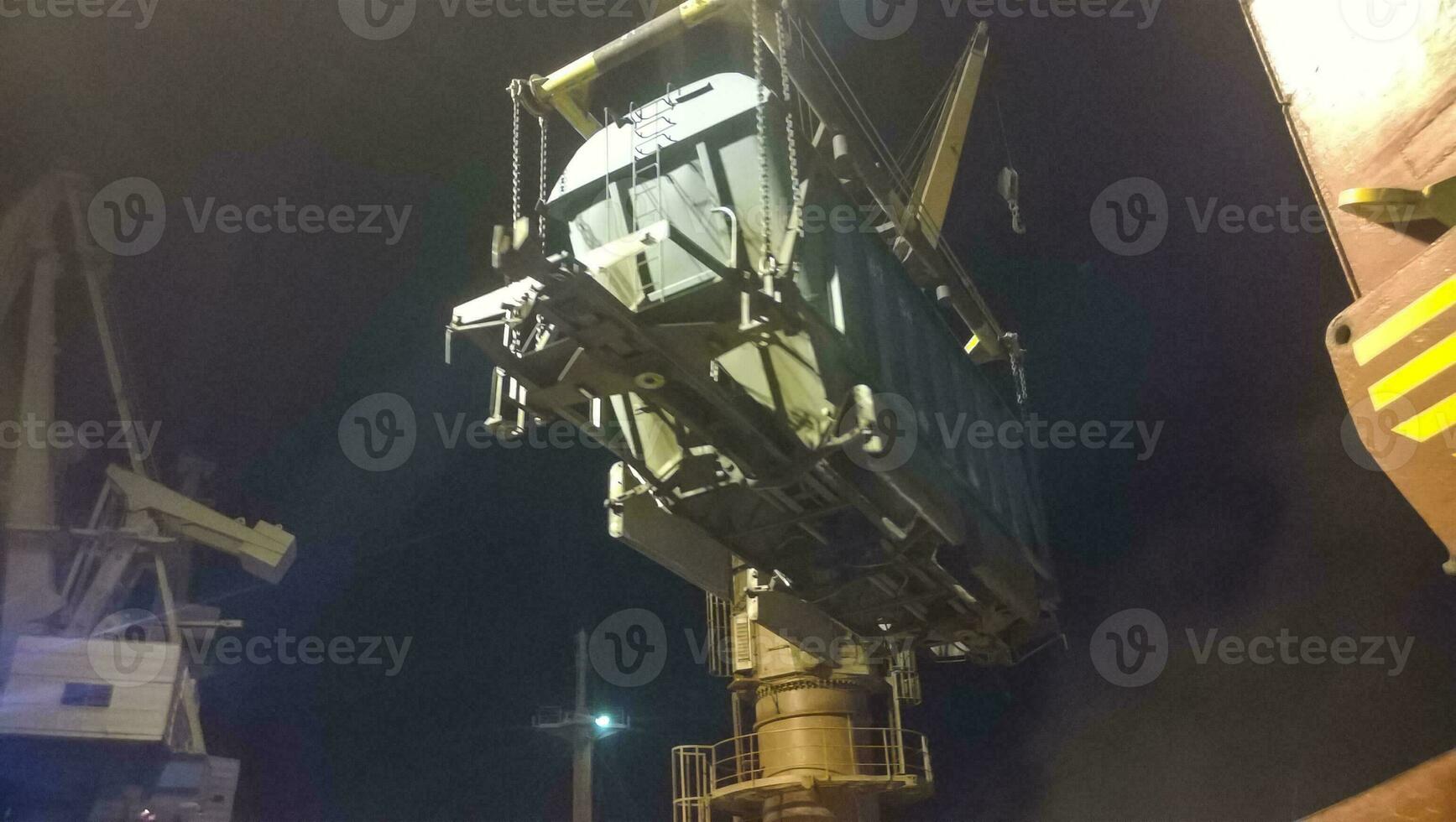 industrial puerto marítimo a noche. el rotación de el coche con grano utilizando un torre grua foto