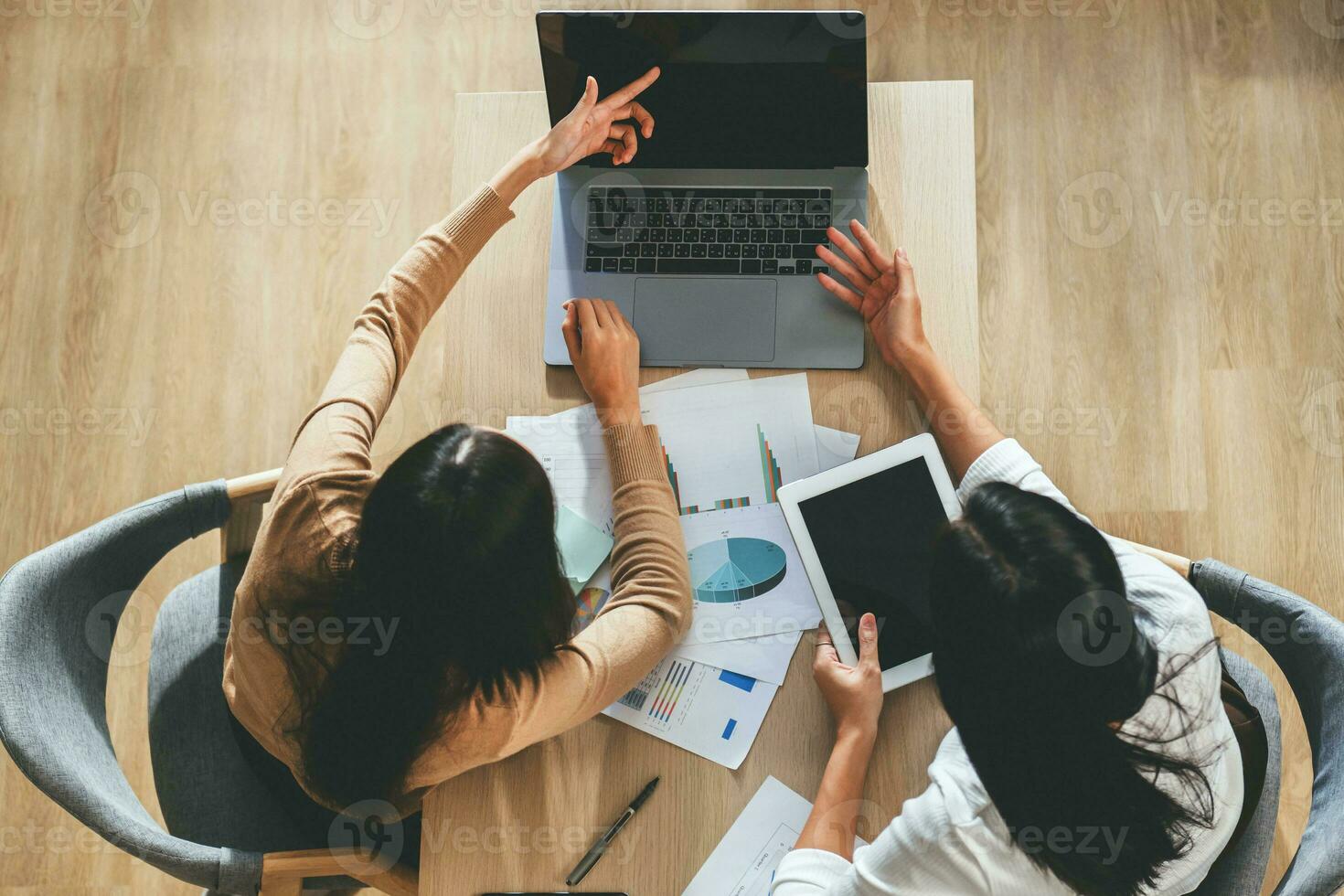 Two female accountants have a team meeting to summarize financial information in the office photo