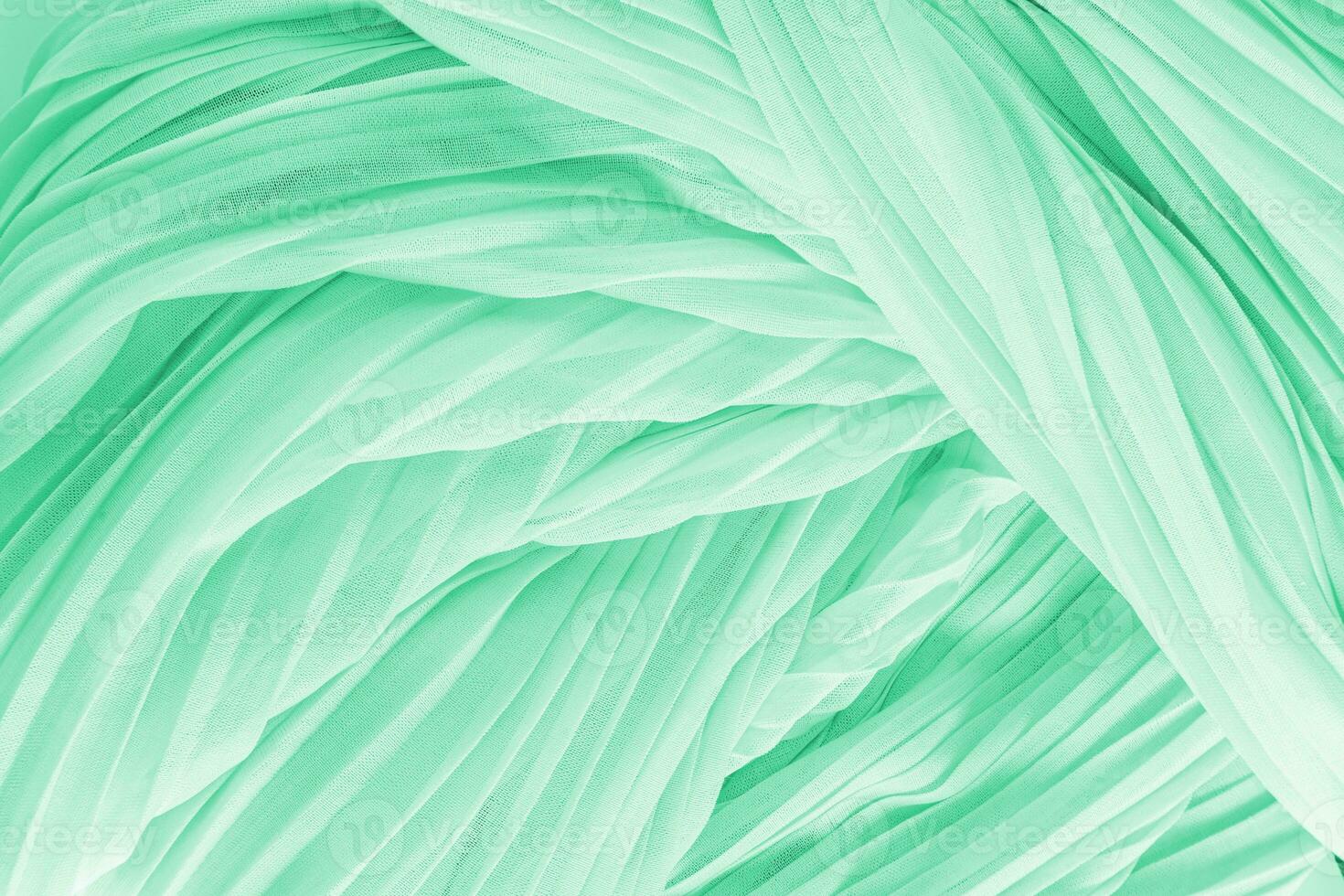 Delicate air waves of mint, green colored silk or chiffon fabric. Layout for design. Background image for holiday decor. A copy space photo
