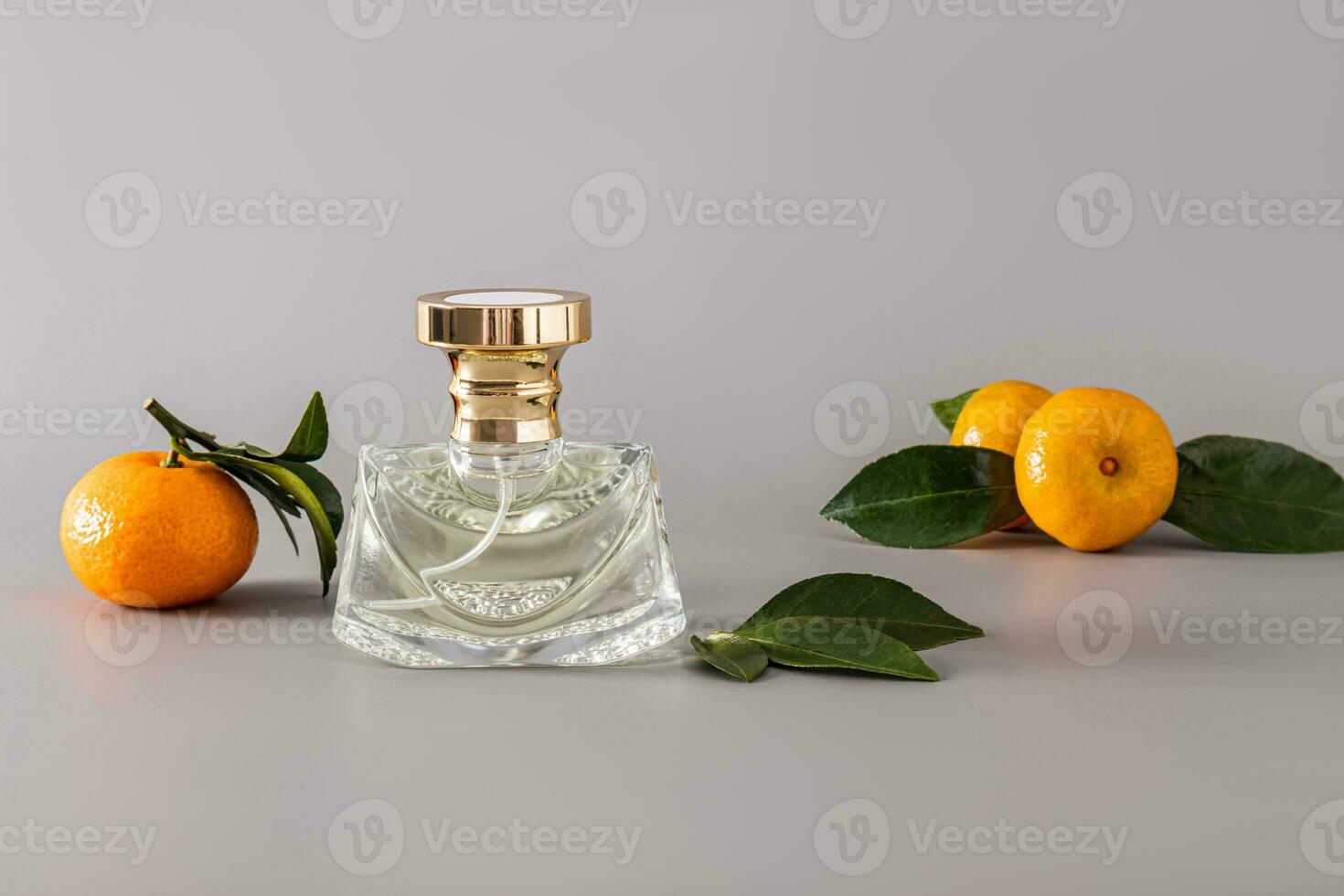 A chic bottle of women's perfume with a delicate aroma with notes of tangerine on a pastel background with ripe fruit. An original smell of freshness. photo