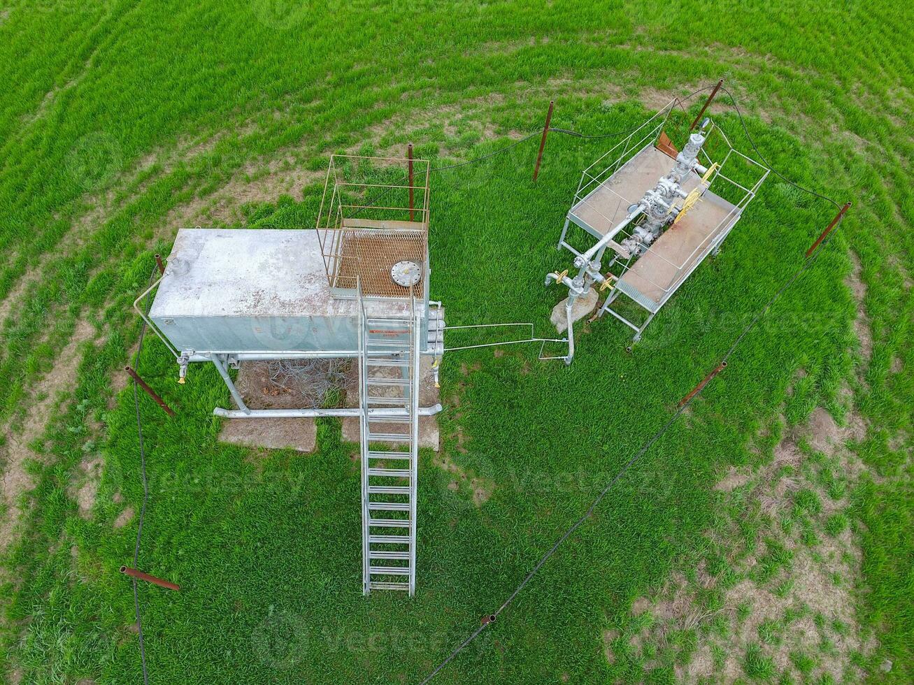 Equipment of an oil well. A tank with methanol near the oil well. Shutoff valves and service equipment photo