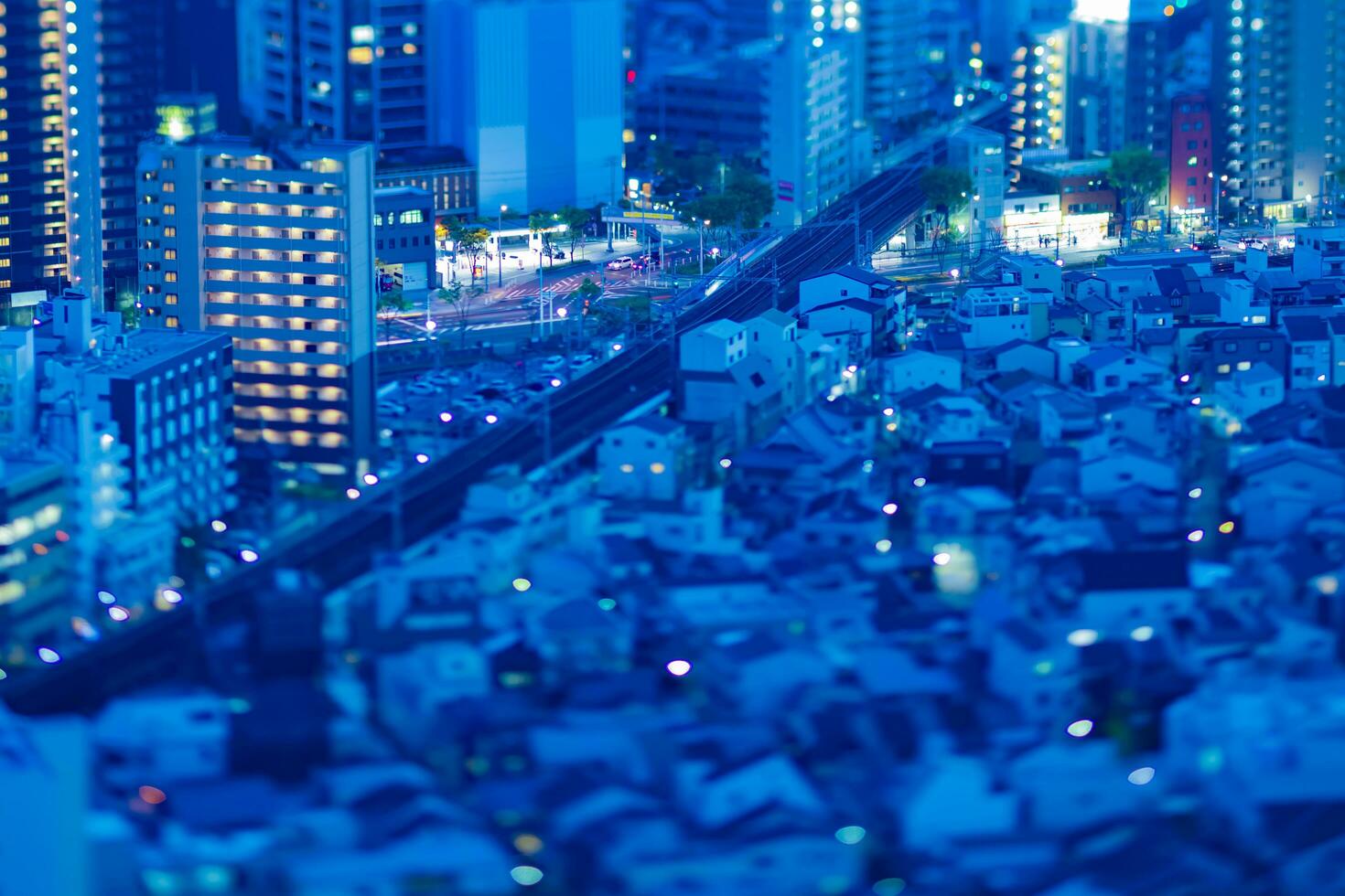 un oscuridad miniatura paisaje urbano por alto ángulo ver cerca el ferrocarril en Osaka foto