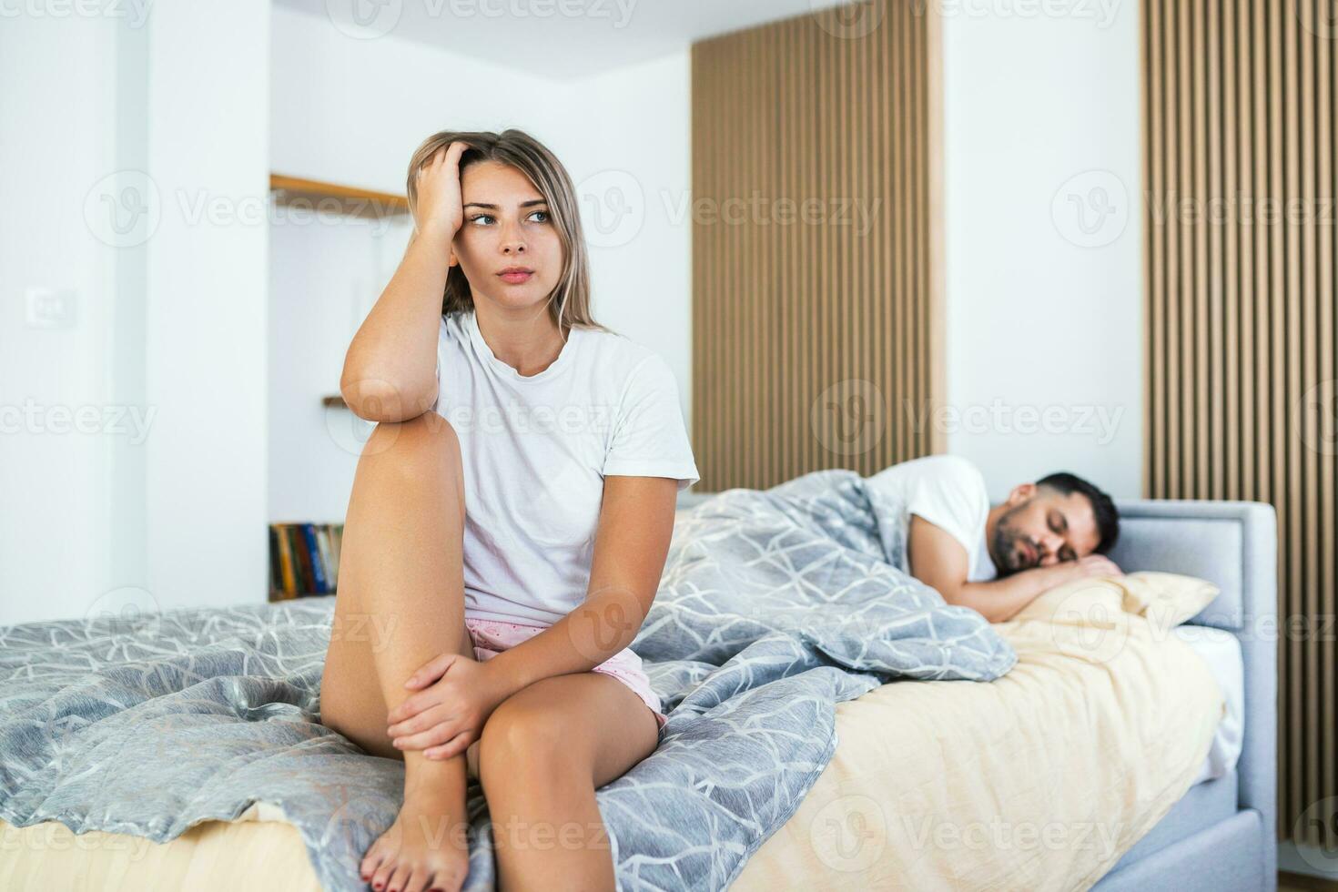 Young couple lying in bed under blanket in bedroom at home, man sleeping, pensive frustrated woman in lingerie thinking about relationships, cheat, treason, family having sexual problems close up photo