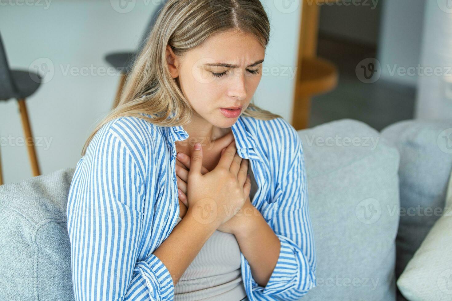 Young woman having chestpain,Acute pain, possible heart attack.Effect of stress and unhealthy lifestyle concept. photo