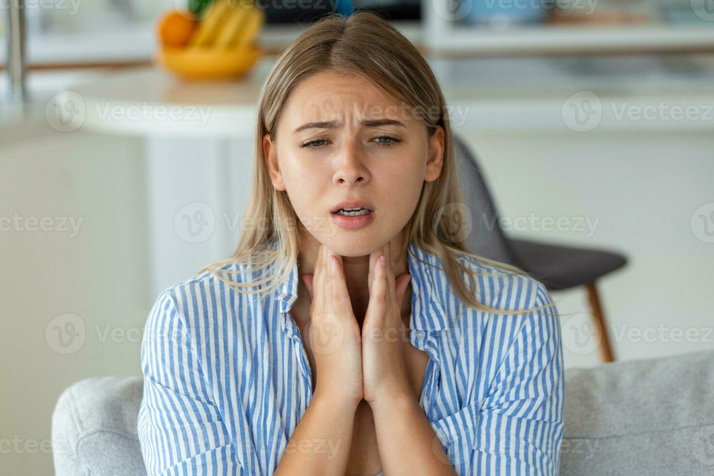 Close up of young woman rubbing her inflamed tonsils, tonsilitis problem, cropped. Woman with thyroid gland problem, touching her neck, girl has a sore throat photo