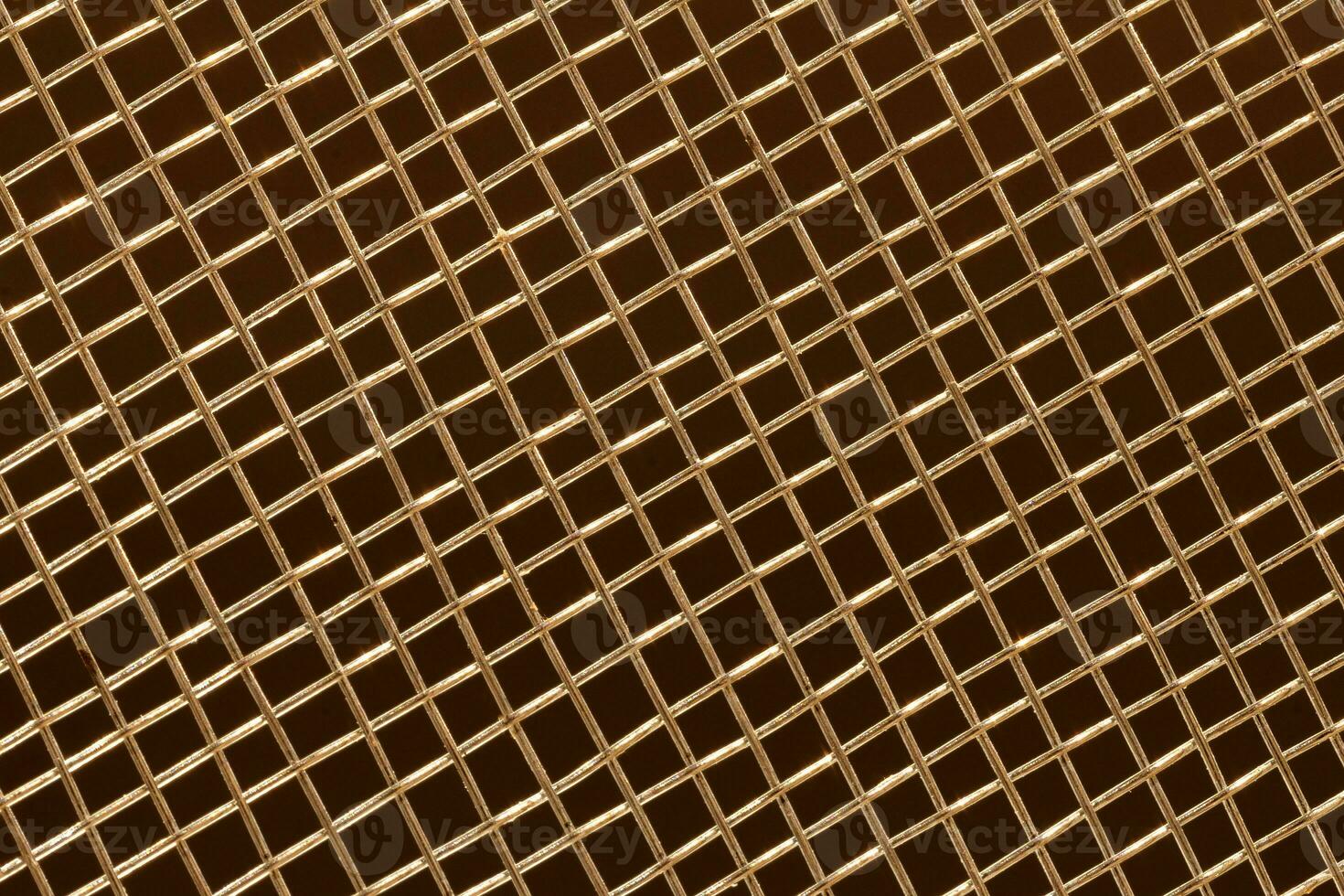 grid with a pattern of numerous small shaped cells on dark background, close view photo