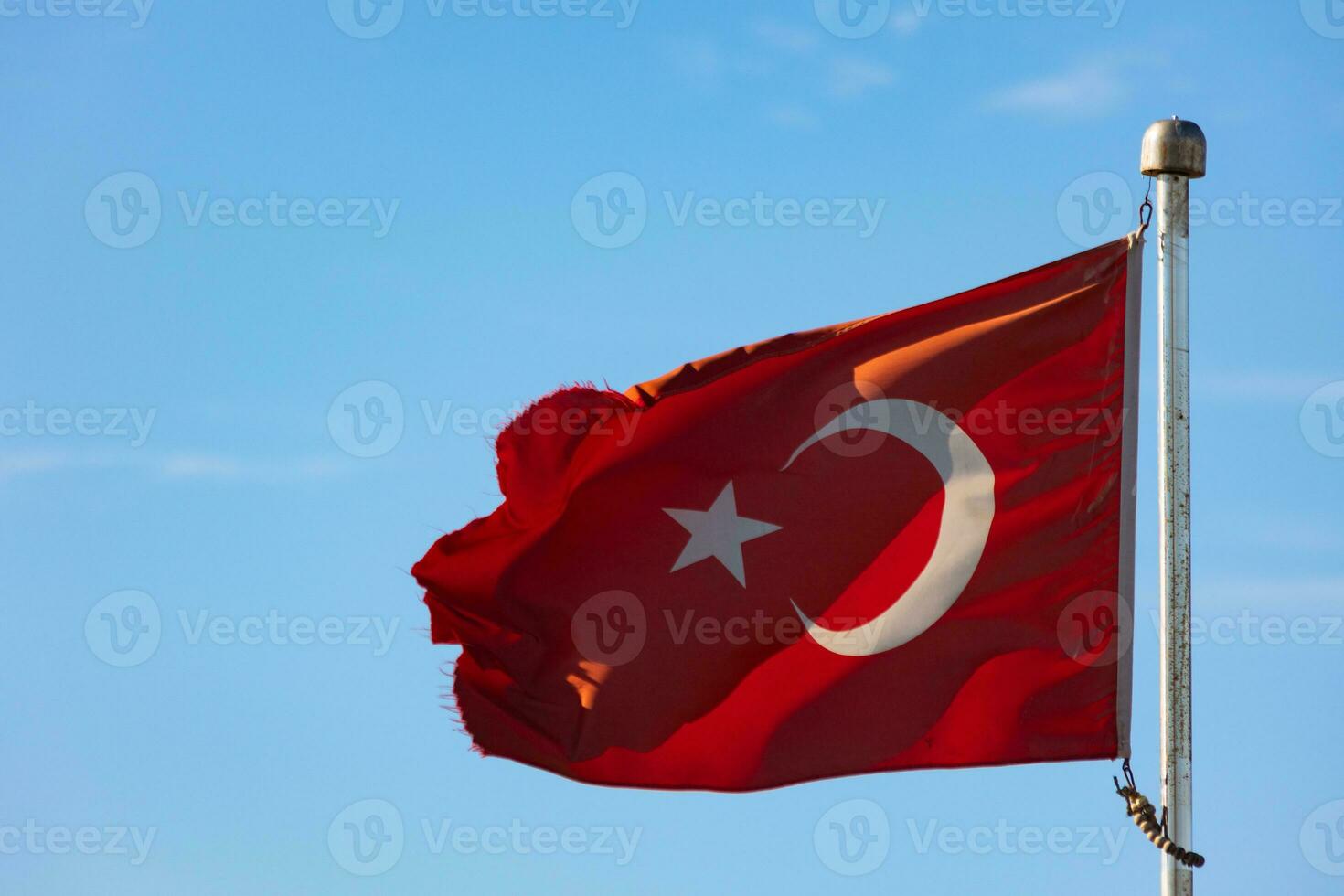 Turkish Flag aka Turk Bayragi isolated on blue sky background. photo