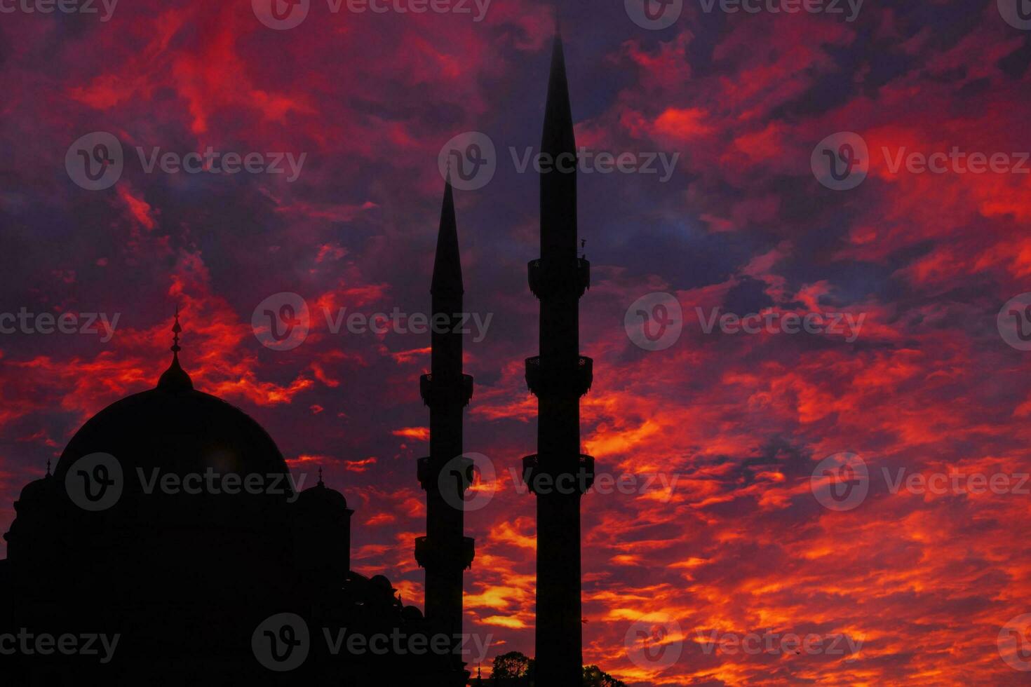 Islamic concept image. Silhouette of a mosque with dramatic clouds at sunset photo