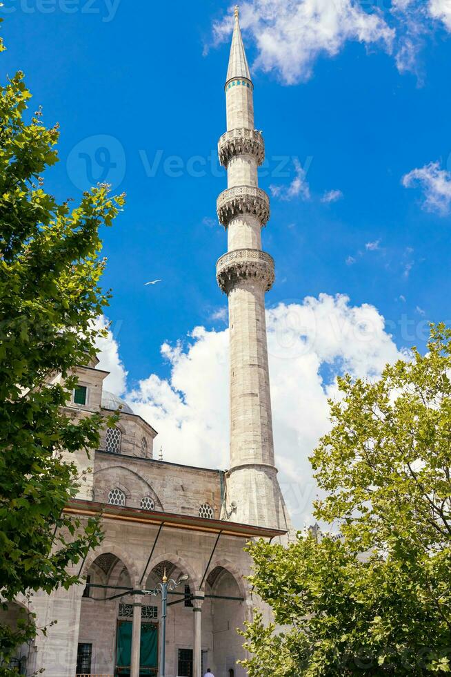 Islamic vertical photo. Minaret of Eminonu New Mosque or Yeni Cami in Istanbul photo