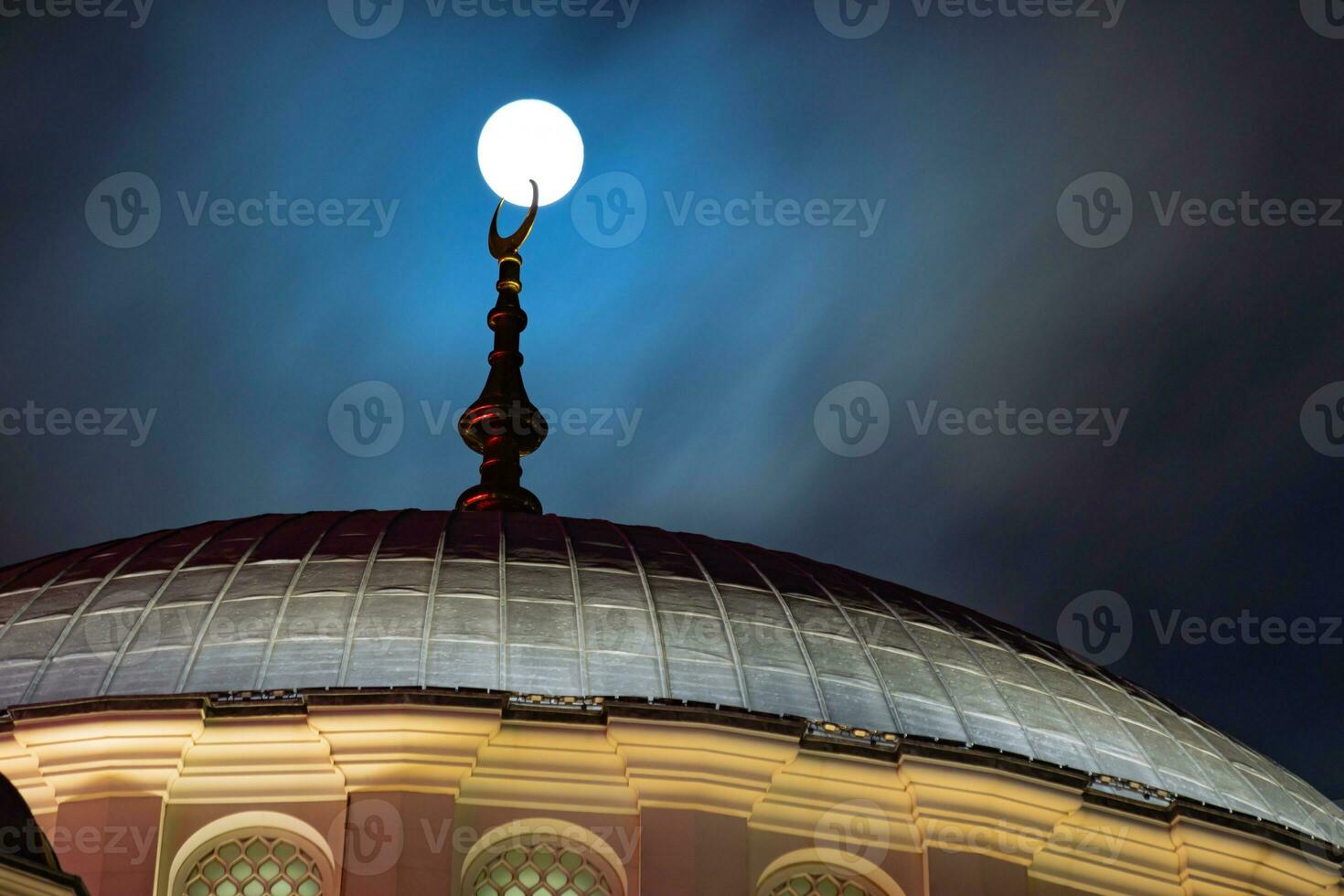 Islamic background photo. Full moon touches of the finial of a mosque's dome. photo