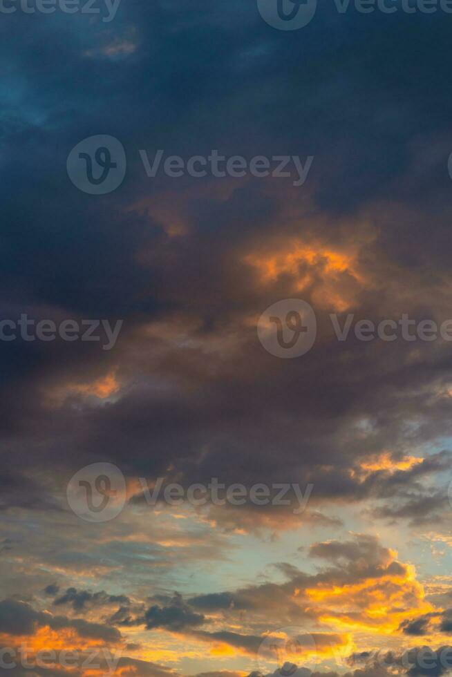 Dramatic clouds at sunrise. Partly cloudy sky vertical background photo